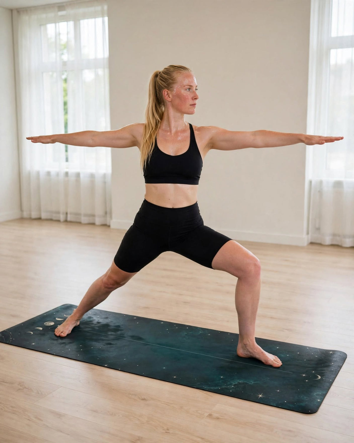 Woman practicing on the Best Yoga Mat For Hot Yoga in teal lunar phases, showcasing a strong warrior pose.