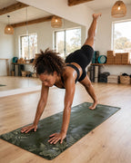 Best Yoga Mat For Hot Yoga in Emerald Fern color, woman practicing yoga in a studio environment.
