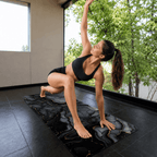 Woman practicing on the Hot Yoga Mat - Onyx Flow | MIYRA®, showcasing its sweat-activated grip and non-slip surface.